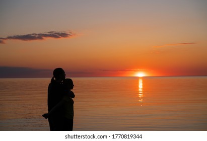 Amazing Sunset.Cute Couple Siluett On The Sunset Background. People On The Image - Unrecognizable.  Orange Sunset - Golden Hour During Estonian Mid Summer Fest. Darker Images With High Resolution
