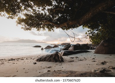 Amazing Travel Landscape During Sunset On La Digue With Beautiful View On A Hammock With Iconic Rocks Of Seychelles, Travel Lust Concept