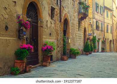 Amazing tuscan street view. Cute medieval stone houses and paved street with flowery entrances, Pienza, Tuscany, Italy, Europe