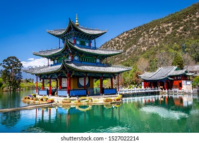 Amazing view of the Jade Dragon Snow Mountain and the Black Dragon Pool, Lijiang, Yunnan province, China. The Suocui Bridge over pond and the Moon Embracing Pavilion in the Jade Spring Park