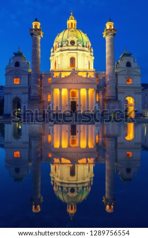 Amazing view of Karlskirche or St. Charles's Church - one of famous churches in Vienna - under picturesque twilight sky with illumination and reflection in the water at early morning, Vienna, Austria