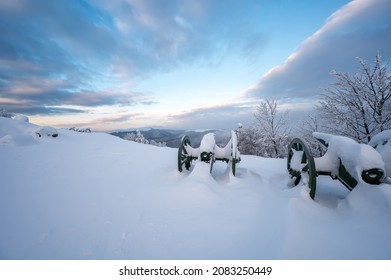 Amazing view with mists over the old cannons at Shipka Monument and the snow-covered mountain slopes of Balkan Mountains at sunrise	