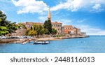 Amazing view of old Assumption of Mary church with sea and boats in foreground. Cityscape of Porec, Croatia, Europe. Traveling concept background