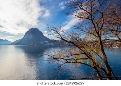 Amazing view on park with autumn leaf color and Lugano town on other side of lake and San Salvatore mount. View from Ciani park - Shutterstock ID 2242926297