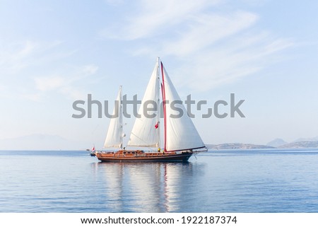 Amazing view to sailboat with white sails in the sea