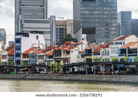 Amazing view of skyscrapers and traditional old buildings in Boat Quay in Singapore. Modern high-rise buildings above old houses.