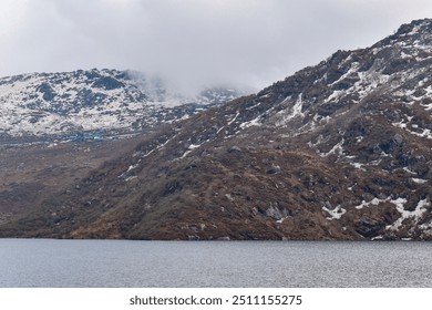 Amazing view of snow covered mountains with first snow. Season change in the Himalaya highlands. Melting snow peaks result of global warming. Snow mountains under a partly cloudy sky. sstkbackgrounds - Powered by Shutterstock