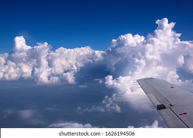 Amazing view of the snow-covered mountain from the plane window. Travel to the top of the hill - Powered by Shutterstock