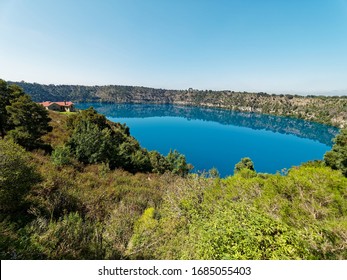 Amazing Volcano Crater Blue Lake with stunning reflection of the Crater Rim and historic pumping station for town water supply.  Blue colour between November and March. Mount Gambier,  South Australia