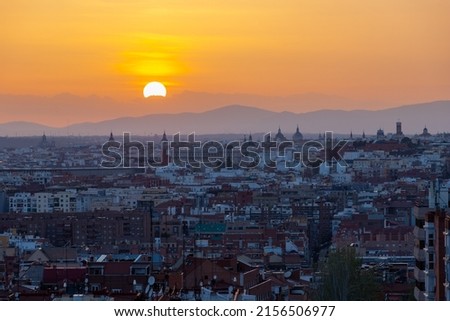An amazing warm sunset over the skyline of Madrid with views on the mountain range on the horizon, seen from a lookout point in the East of the city. 