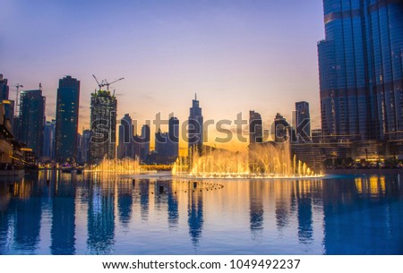 Amazing water fountain near Dubai mall and Burj khalifa, Famous tourist attraction, blue lake with colorful water dance fountain, Dubai Travel and tourism concept image