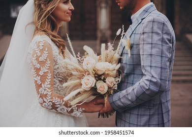 Amazing Wedding Couple. Pretty Bride And Stylish Groom Holding Boho Bouquet