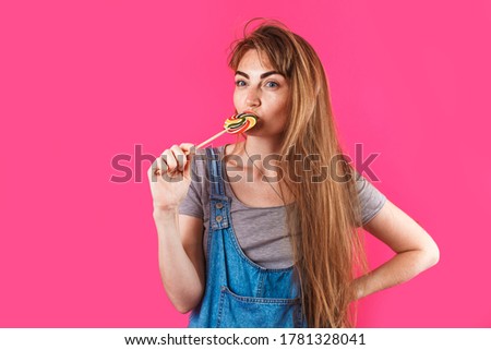amazing woman with candy. isolated on pink background. copy space