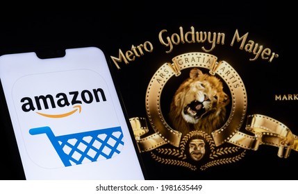 Amazon App Logo Seen On The Smartphone And Blurred Metro Goldwyn Mayer Logo On The Laptop. Stafford, United Kingdom, May 27, 2021.