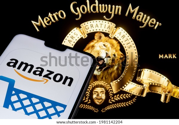 Amazon app logo seen on the\
smartphone and blurred Metro Goldwyn Mayer logo on the laptop.\
Concept for merger and acquisition. Stafford, United Kingdom, May\
27, 2021.