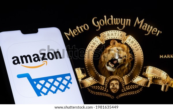 Amazon app logo seen on the smartphone and blurred\
Metro Goldwyn Mayer logo on the laptop. Stafford, United Kingdom,\
May 27, 2021.