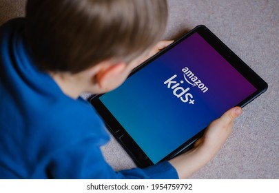 Amazon Kids + App Logo Seen On The Ipad Screen Hold In Young Childs Hands. Concept For Child Entertaining App From Amazon. Not A Montage, Real Photo. Stafford, United Kingdom, April 12, 2021.