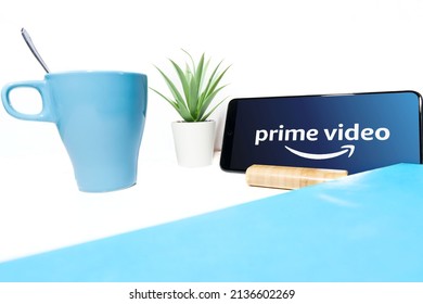 Amazon Prime Video Logo On The Mobile Phone, On A White Background, Time To Relax With A Coffee And A Good Story With Amazon Prime Video.