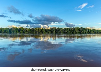Amazon river landscape with sunset cloud reflection, Iquitos, Peru. The tributaries of the river flow through (French) Guyana, Venezuela, Colombia, Ecuador, Peru, Bolivia, Suriname, Brazil.