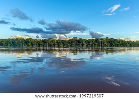 Amazon river landscape with sunset cloud reflection, Iquitos, Peru. The tributaries of the river flow through (French) Guyana, Venezuela, Colombia, Ecuador, Peru, Bolivia, Suriname, Brazil.