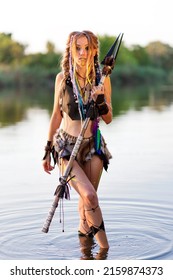 Amazon Woman In A Fur Medieval Costume With A Spear In Her Hand, In War Paint, Fords The River.