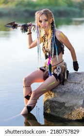 Amazon Woman In A Fur Medieval Costume With A Spear In Her Hand, In War Paint, Leaned On A Stone.