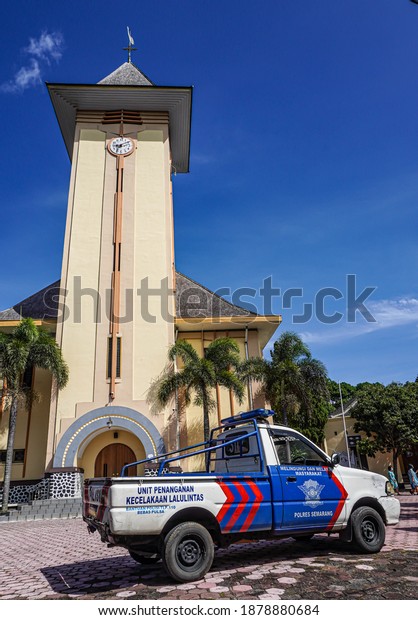 Ambarawa, Central Java, Indonesia - December 20 2020\
: Police patrol car stands guard in front of the Catholic Church of\
Saint Joseph Ambarawa during Mass, preparation for 2020 Christmas\
Mass