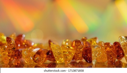 Amber Beads On A Colored Background. Decoration, Copy Space. Rainbow, Macro.