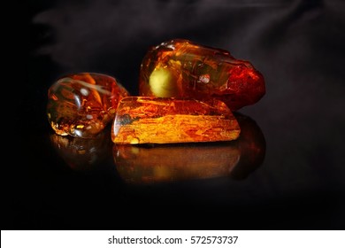 Amber. Beautiful composition of three unique pieces of amber on a black background.
Reflections amber with smoke.