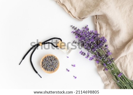 Amber bottle of lavender essential oil. Flat lay concept skin care. Light background with lavend flower.