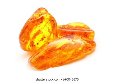 Amber. Bright yellow stone of resin on a white background.
Sunstone amber texture. Mineral for jewelry. Vintage ancient resin. Baltic amber. Colored bright pieces of  resin. Amber stone texture