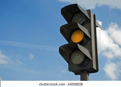 Amber color on the traffic light with a beautiful blue sky in background