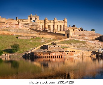 Amber Fort illuminated by warm light of the rising sun and reflected in the lake. Famous Rajasthan landmark located nearby Jaipur city in north-western India.
