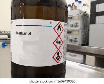 Amber glass bottle for lightning protection containing methanol, an alcohol, and a label with warnings about toxicity, flammability and death. Chemical reagent in a laboratory.