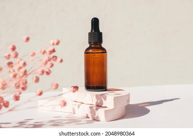 Amber glass dropper bottle with black lid on a podium with dry plants on light background. Skincare products , natural cosmetic. Beauty concept for face and body care - Shutterstock ID 2048980364