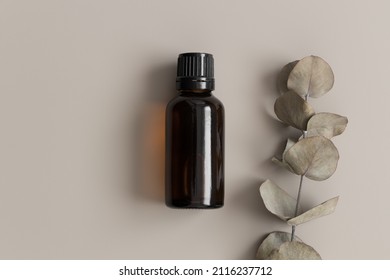 Amber Glass Essential Oil Bottle Mockup With An Eucalyptus On The Beige Background.