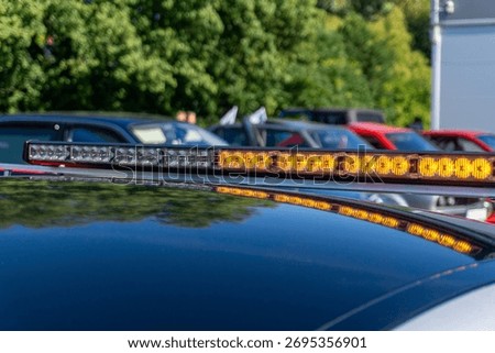 Amber LED warning light bar on the roof of a technical vehicle during a vintage vehicle rally