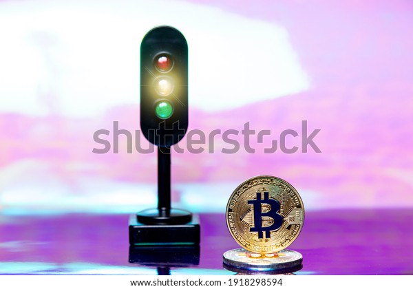 Amber (orange\
or yellow) traffic light and bitcoin - symbol of danger to operate\
and warning. Gold metal btc\
symbol