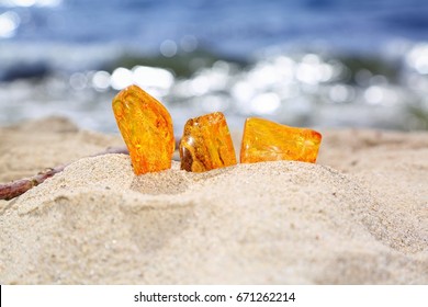 Amber in the sand against the background of sea waves. 