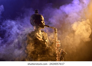 Ambient side view portrait of Black young woman playing saxophone in cloud of neon colored smoke copy space - Powered by Shutterstock