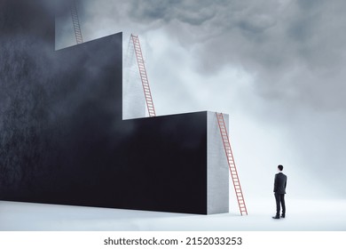 Ambition and career growth concept with man staying in front of red ladder leaning on a monumental wall in the form of stairs - Shutterstock ID 2152033253