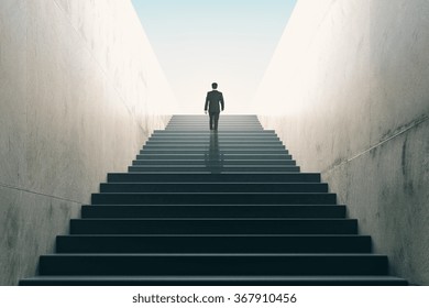 Ambitions concept with businessman climbing stairs 