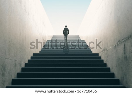 Ambitions concept with businessman climbing stairs 