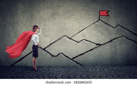 Ambitious Business Woman Looking At The Top Of The Mountain With Red Flag