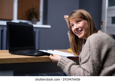 Ambitious freelance girl sitting at home with laptop and looking side, in distance, smiling. Woman working on computer in living room. High quality photo