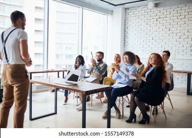 Ambitious young caucasian coach leader give presentation to co-workers sitting listening to him in modern office - Shutterstock ID 1557149378