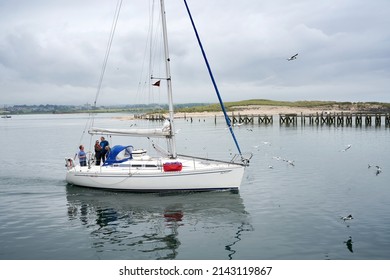 AMBLE, ENGLAND, UK - JULY 13, 2019: A Group Of Adults Heading Out To Sea On A Sailing Yacht From Amble Harbour In The UK.