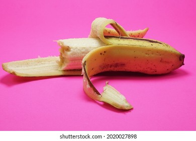 Ambon banana that have been peeled and partially bitten on isolated pink background 