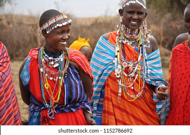 Amboseli National Park, Kenya, September, 2014. Beautiful maasai tribe women with traditional colorful ornaments (necklace, earrings) smiling and greeting tourists with traditional jumping dance