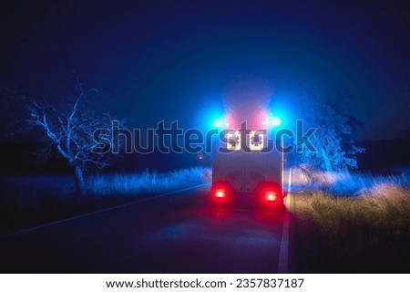 Ambulance car of emergency medical service on road at night. Themes rescue, urgency and health care. 
